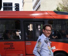 Cena da performance Arte Panfletária, onde aparece o artista Elilson em meio ao centro urbano da cidade de Curitiba.