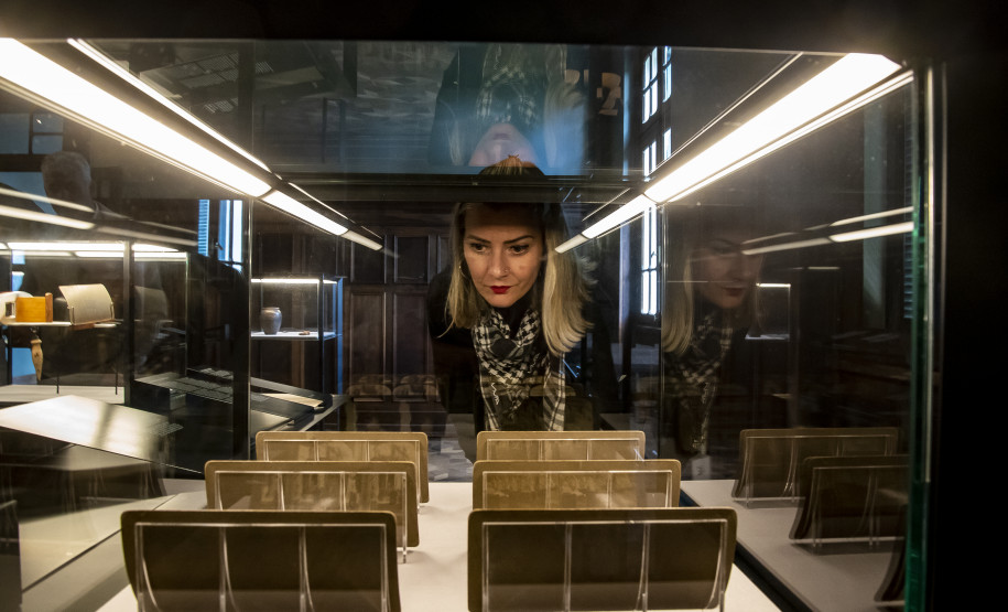 Mulher observa obra em exposição