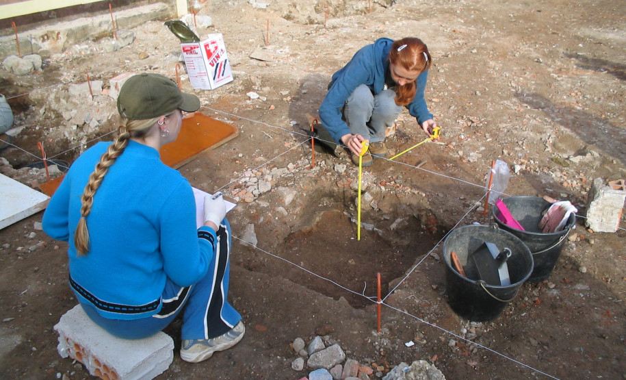 Pesquisadoras documentando materiais evidenciados nas quadras